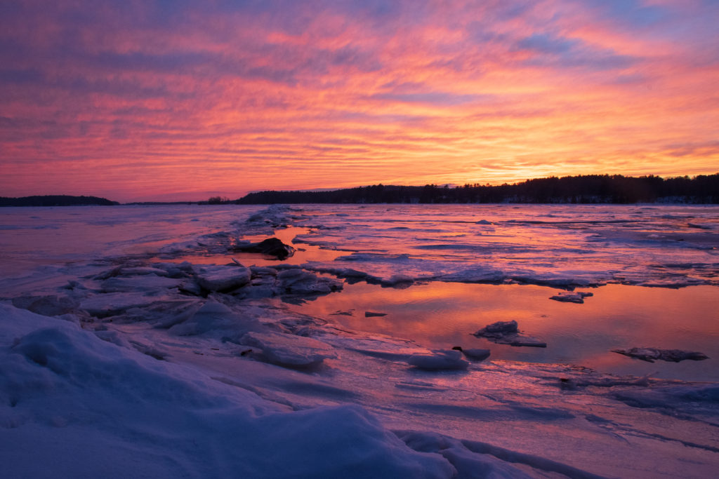 Sun sets over ice and water on Merrymeeting Bay, Maine